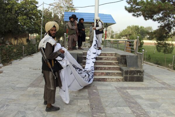 Taliban fighters raise their flag at the Ghazni provincial governor's house, in Ghazni, southeastern, Afghanistan, Sunday, 15 August 2021.  - Sputnik International