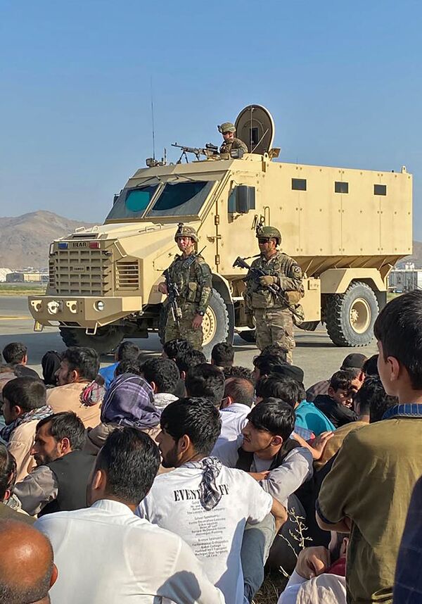 Afghans crowd at the airport as US soldiers stand guard in Kabul on 16 August 2021. - Sputnik International
