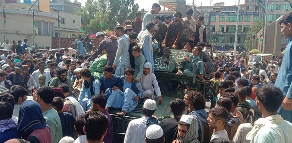 Taliban fighters and local people sit on an Afghan National Army (ANA) Humvee vehicle on a street in Jalalabad province on 15 August 2021.  - Sputnik International