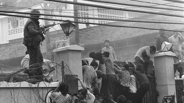 People clamber into the US embassy compound during the fall of Saigon in 1975 - Sputnik International