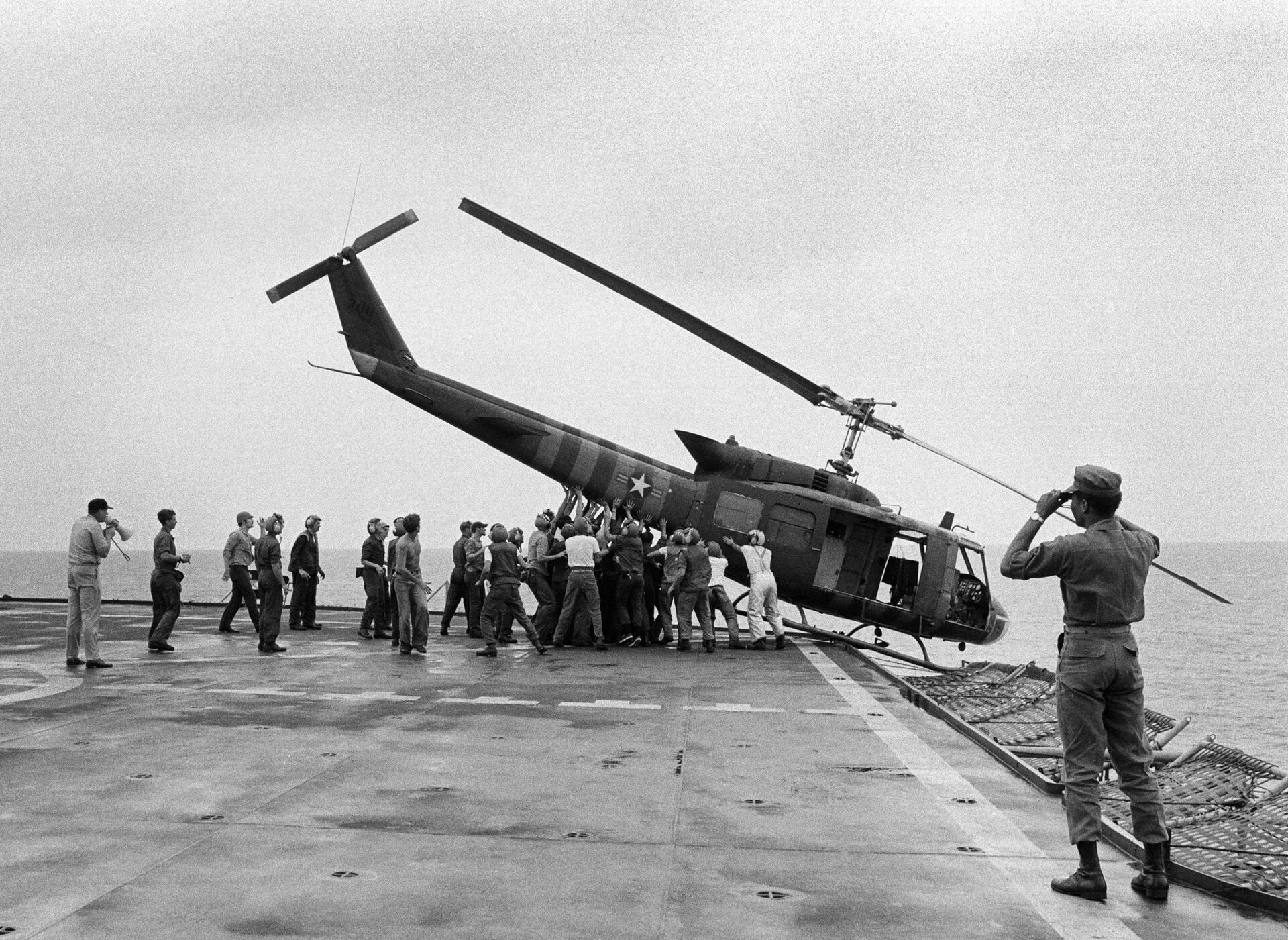A helicopter is pushed overboard from USS Blue Ridge on the eve of the fall of Saigon - Sputnik International, 1920, 09.09.2021