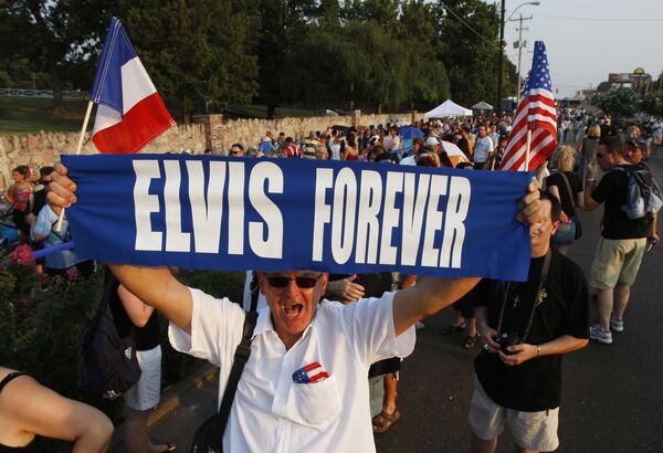 Elvis Presley fan Orlando Bruno of Paris, France holds up a sign as he waits in line to visit Presley's gravesite on the eve of the 30th anniversary of Presley's death, 15 August 2007 at Graceland, Presley's home in Memphis, Tennessee. - Sputnik International