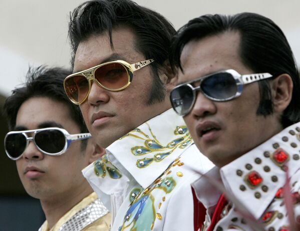 Filipino Elvis Presley impersonators, from left, Bjorn Rono, Richie Barangan, and Lito Jaurejui, pose prior to a performance on Sunday, 15 August 2010 in Manila, Philippines to pay tribute to the King of Rock 'n' Roll on his 33rd death anniversary. About 30 impersonators took part in the singing contest. - Sputnik International