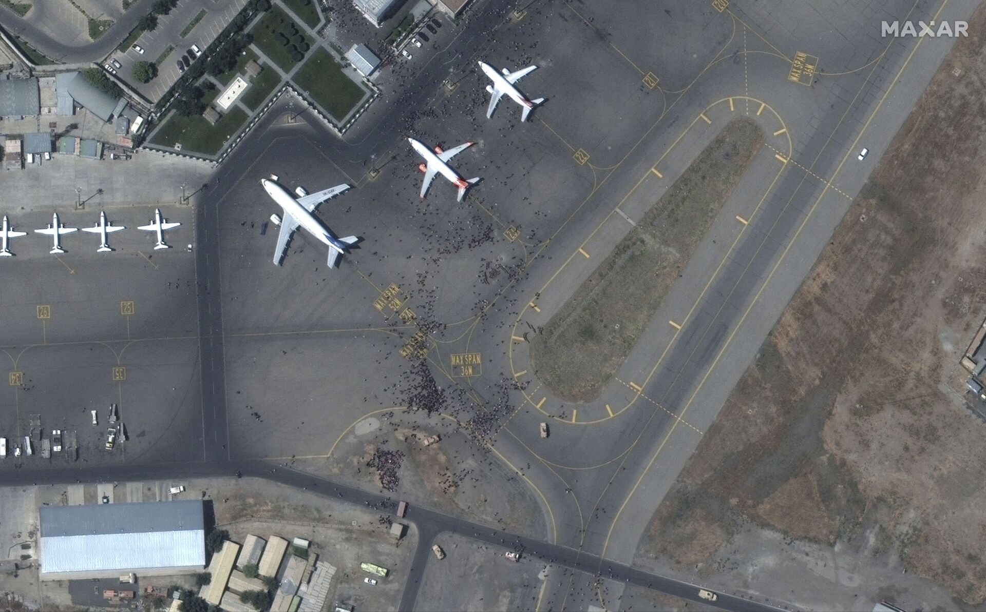 This handout satellite image released by Maxar Technologies shows crowds of people on the tarmac, during the chaotic scene underway at Kabul’s Hamid Karzai International Airport in Afghanistan as thousands of people converged on the tarmac and airport runways as countries attempt to evacuate personnel from the city on August 16, 2021. - Sputnik International, 1920, 07.09.2021