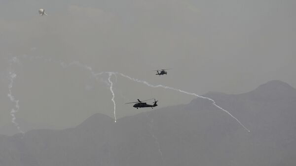 Anti-missile decoy flares are deployed as U.S. Black Hawk military helicopters and a dirigible balloon fly over the city of Kabul, Afghanistan, Sunday, Aug. 15, 2021. - Sputnik International