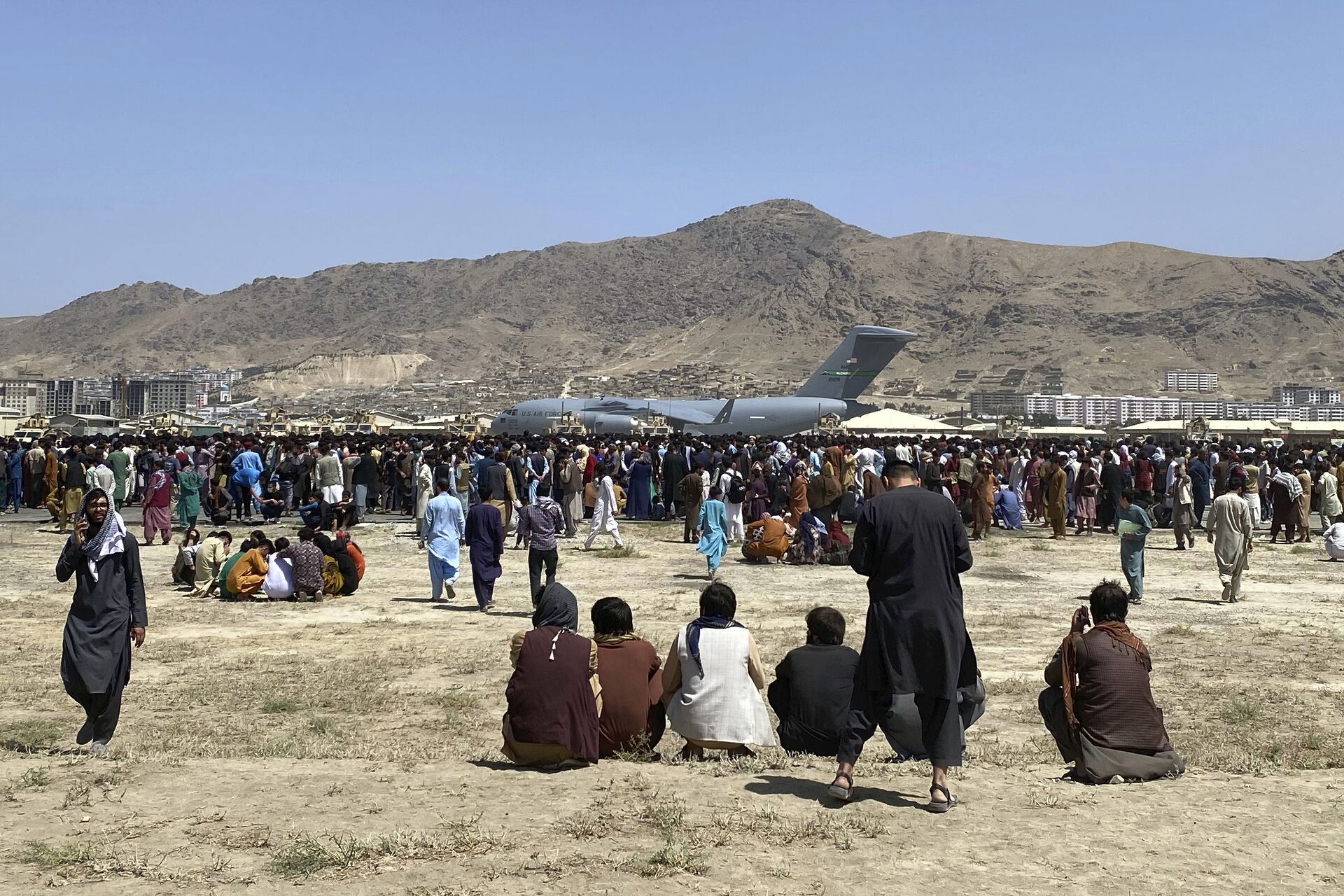 Hundreds of people gather near a U.S. Air Force C-17 transport plane at a perimeter at the international airport in Kabul, Afghanistan, Monday, Aug. 16, 2021 - Sputnik International, 1920, 07.09.2021