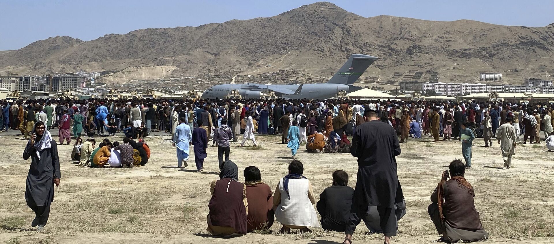 Hundreds of people gather near a U.S. Air Force C-17 transport plane at a perimeter at the international airport in Kabul, Afghanistan, Monday, Aug. 16, 2021 - Sputnik International, 1920, 18.08.2021