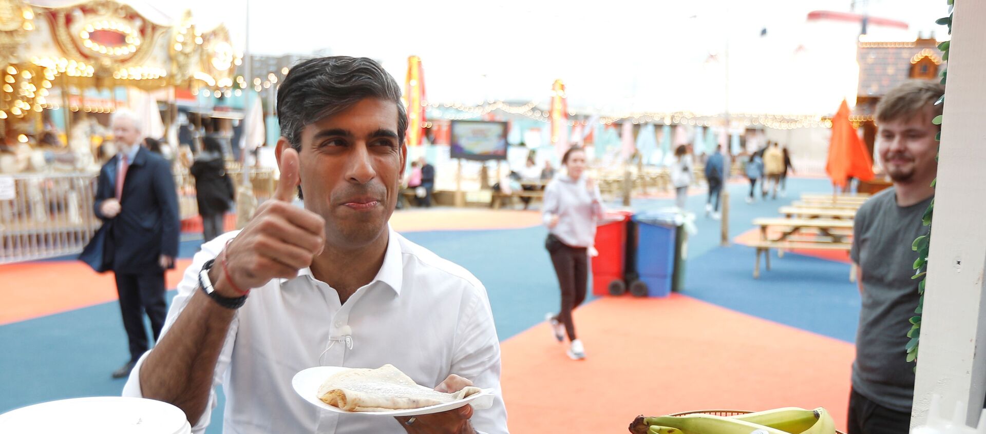 Britain’s Chancellor Rishi Sunak takes a pancake from a stall at the London Wonderground comedy and music festival venue in London - Sputnik International, 1920, 17.08.2021