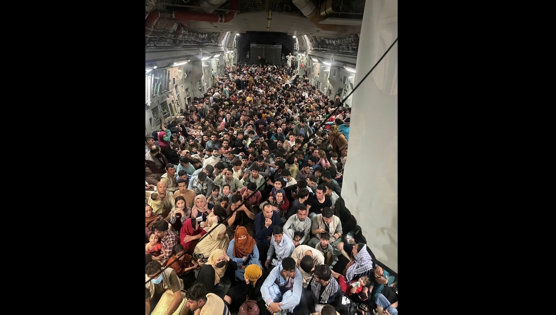 Evacuees crowd the interior of a U.S. Air Force C-17 Globemaster III transport aircraft, carrying some 640 Afghans to Qatar from Kabul, Afghanistan August 15, 2021. Picture taken August 15, 2021 - Sputnik International, 1920, 07.09.2021