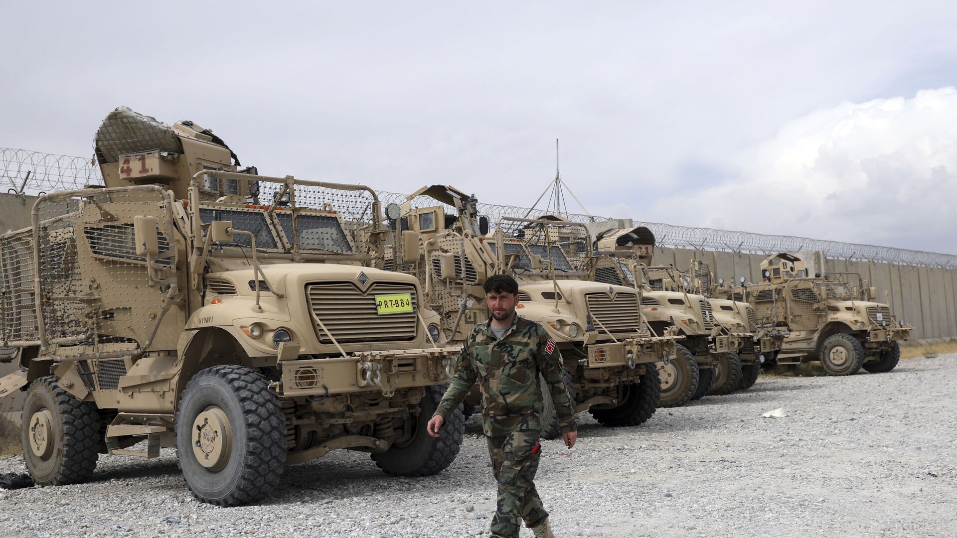 An Afghan army soldier walks past Mine Resistant Ambush Protected vehicles, MRAP, that were left after the American military left Bagram air base, in Parwan province north of Kabul, Afghanistan, Monday, July 5, 2021. - Sputnik International, 1920, 06.10.2021