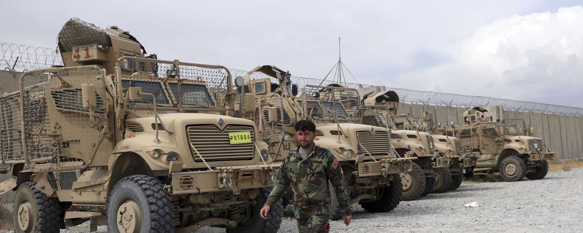 An Afghan army soldier walks past Mine Resistant Ambush Protected vehicles, MRAP, that were left after the American military left Bagram air base, in Parwan province north of Kabul, Afghanistan, Monday, 5 July 2021. - Sputnik International, 1920, 04.09.2021