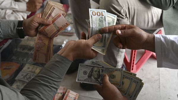A currency dealer (R) counts US dollars at the Shahzada exchange market in Kabul on June 21, 2021 - Sputnik International