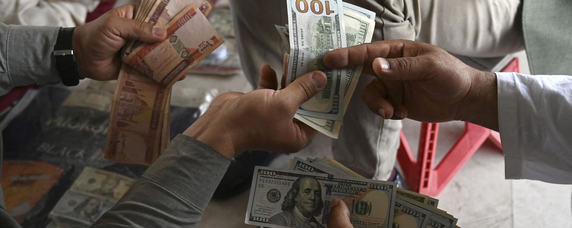 A currency dealer (R) counts US dollars at the Shahzada exchange market in Kabul on June 21, 2021 - Sputnik International, 1920, 23.02.2022