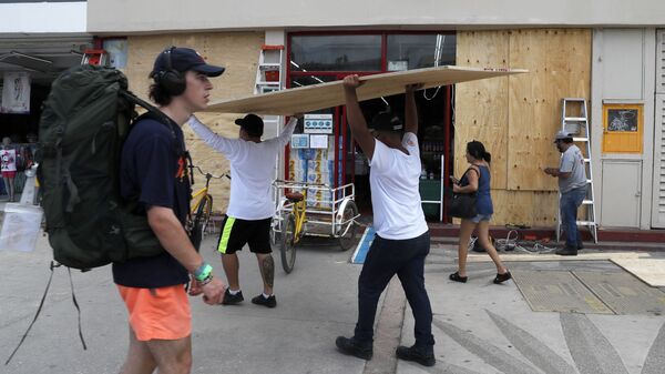 Workers cover shop windows with plywood in Tulum, Quintana Roo State, Mexico, Wednesday, Aug. 18, 2021. Residents and tourists along the Caribbean coast began making preparations for Grace, a storm that drenched Haiti and Jamaica and is now forecast to hit Mexico´s Yucatan peninsula like a hurricane early Thursday morning. - Sputnik International