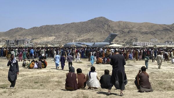 Hundreds of people gather near a U.S. Air Force C-17 transport plane at a perimeter at the international airport in Kabul, Afghanistan, Monday, Aug. 16, 2021. - Sputnik International