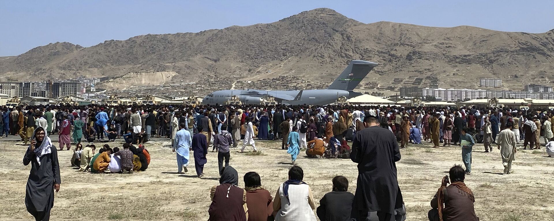 Hundreds of people gather near a U.S. Air Force C-17 transport plane at a perimeter at the international airport in Kabul, Afghanistan, Monday, Aug. 16, 2021. - Sputnik International, 1920, 09.12.2021