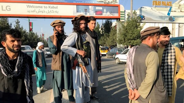 A member of Taliban (C) stands outside Hamid Karzai International Airport in Kabul, Afghanistan, August 16 - Sputnik International