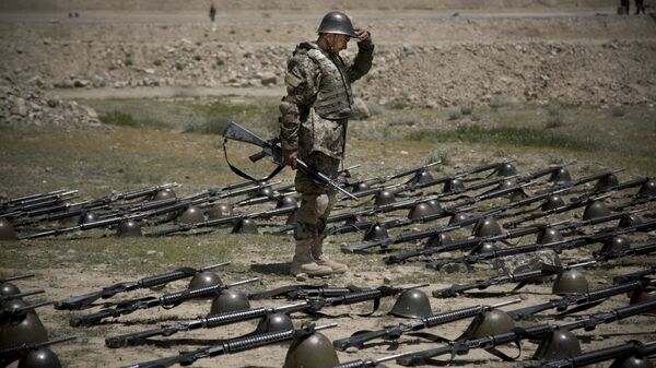 An Afghan Army soldier pauses before dropping his helmet and his gun next to his comrade's equipment at a training facility in the outskirts of Kabul, Afghanistan on Wednesday, May 8, 2013. - Sputnik International