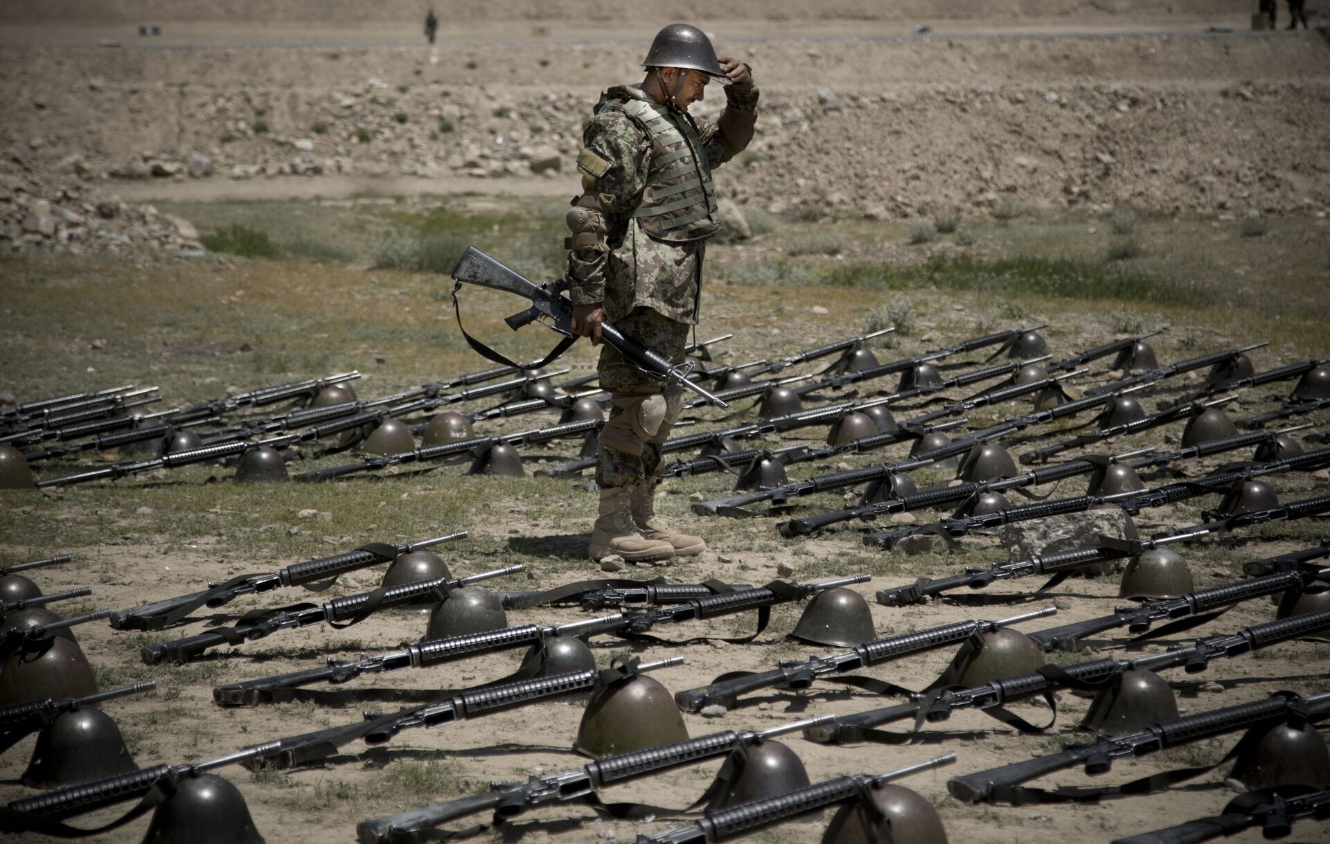 An Afghan Army soldier pauses before dropping his helmet and his gun next to his comrade's equipment at a training facility in the outskirts of Kabul, Afghanistan on Wednesday, May 8, 2013. - Sputnik International, 1920, 07.09.2021