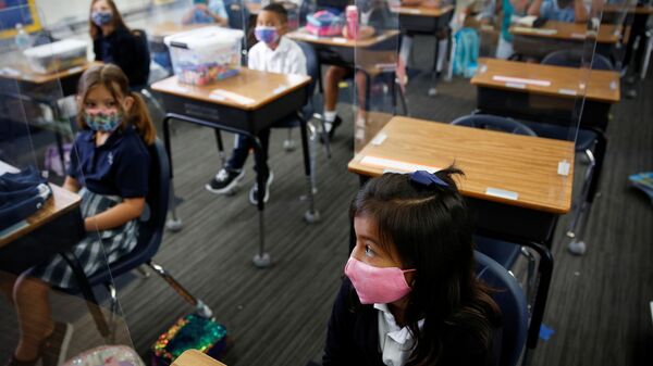 A student wearing a protective mask, attends class on the first day of school, amid the coronavirus disease (COVID-19) pandemic, at St. Lawrence Catholic School in North Miami Beach, Florida, U.S. August 18, 2021. - Sputnik International