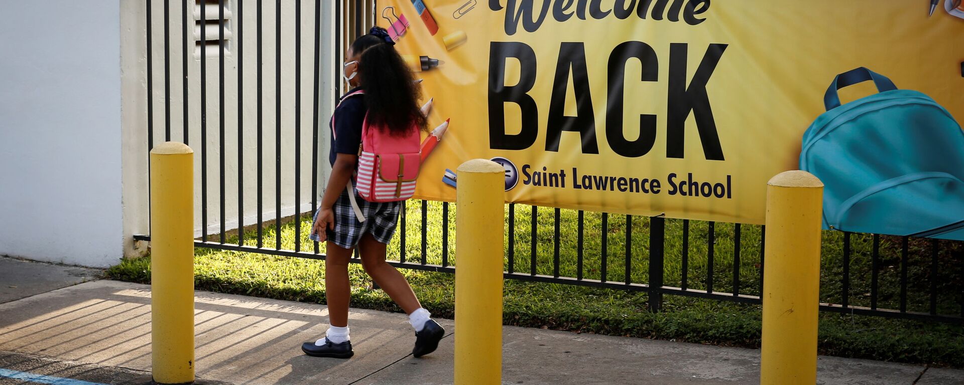 A student wearing a protective masks, walks past a “Welcome back” banner on the first day of school, amid the coronavirus disease (COVID-19) pandemic, at St. Lawrence Catholic School in North Miami Beach, Florida, U.S. August 18, 2021. - Sputnik International, 1920, 29.09.2021
