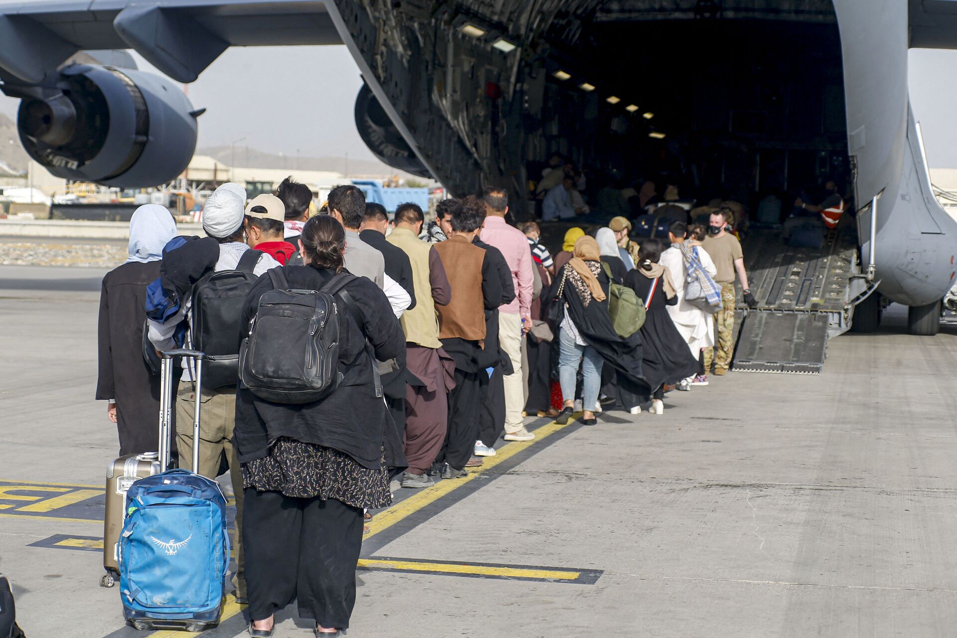 This handout photo courtesy of US Marines Corps shows evacuees stage before boarding a C-17 Globemaster III during an evacuation at Hamid Karzai International Airport, Kabul, Afghanistan, August 18, 2021 - Sputnik International, 1920, 07.09.2021