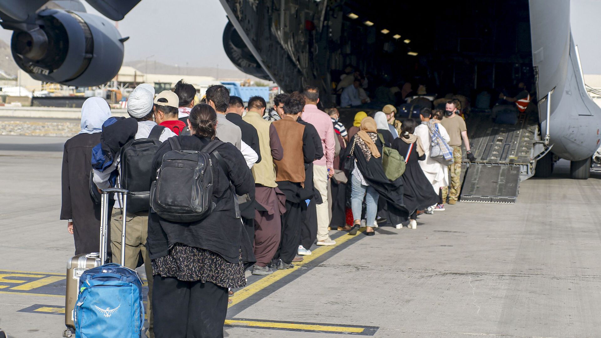 This handout photo courtesy of US Marines Corps shows evacuees stage before boarding a C-17 Globemaster III during an evacuation at Hamid Karzai International Airport, Kabul, Afghanistan, August 18, 2021 - Sputnik International, 1920, 22.08.2021