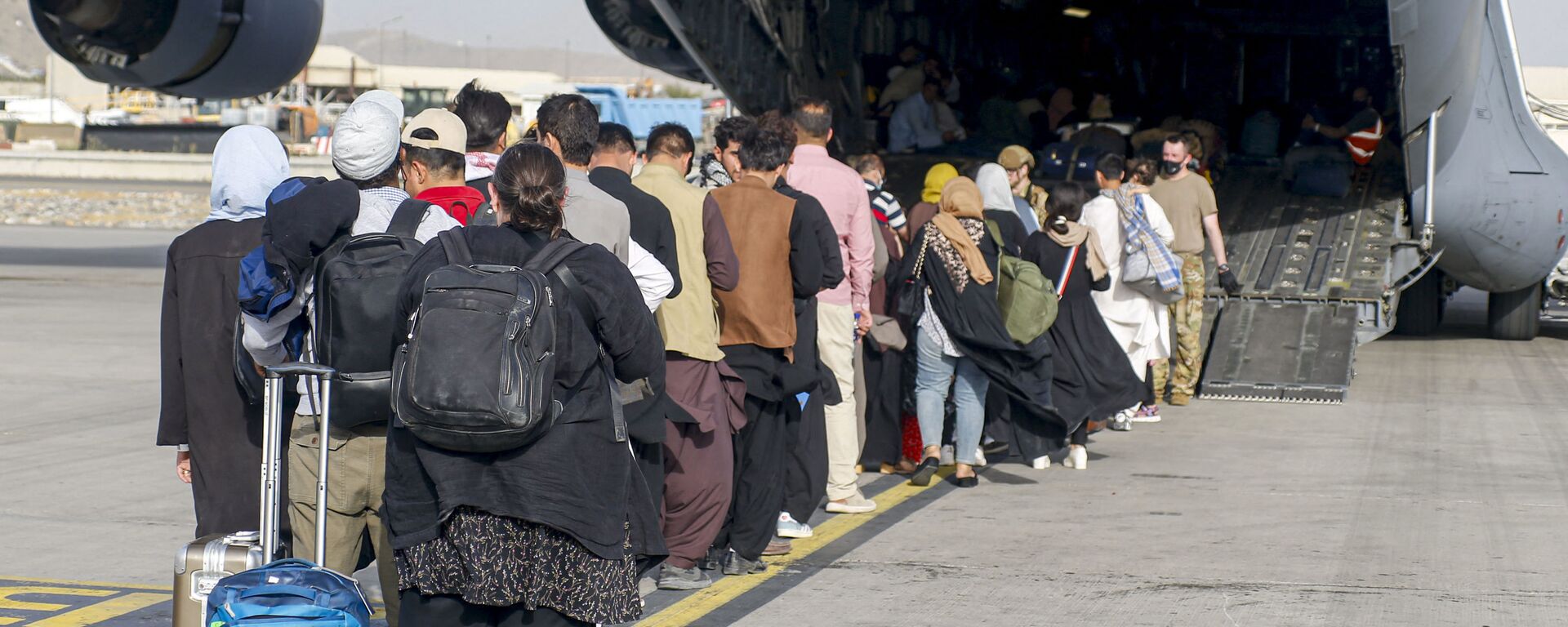 This handout photo courtesy of US Marines Corps shows evacuees stage before boarding a C-17 Globemaster III during an evacuation at Hamid Karzai International Airport, Kabul, Afghanistan, August 18, 2021 - Sputnik International, 1920
