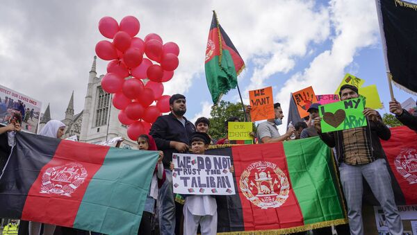 Demonstrators hold Afghanistan flags, during a protest in Parliament Square, London, Wednesday, Aug. 18, 2021.  - Sputnik International