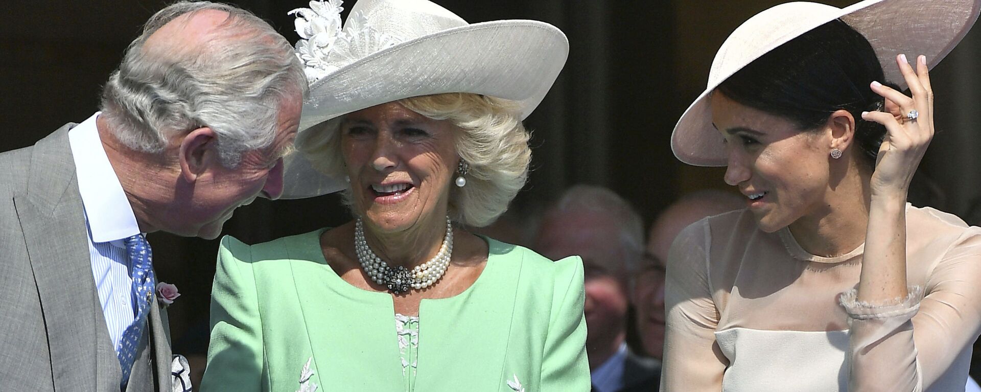 Britian's Prince Charles, left, reacts with Camilla, the Duchess of Cornwall and Meghan, the Duchess of Sussex, during a garden party at Buckingham Palace in London, Tuesday May 22, 2018. - Sputnik International, 1920, 06.02.2022