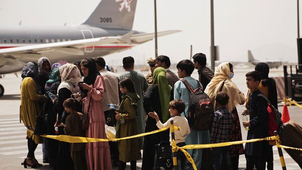 In this photo provided by the U.S. Marine Corps, civilians prepare to board a plane during an evacuation at Hamid Karzai International Airport, Kabul, Afghanistan, Wednesday, Aug. 18, 2021.  - Sputnik International