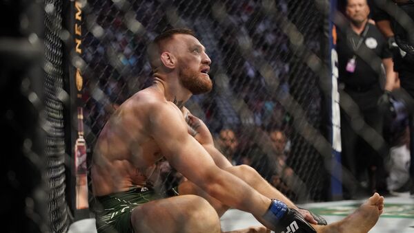 Conor McGregor holds his left ankle while fighting Dustin Poirier during a UFC 264 lightweight mixed martial arts bout Saturday, July 10, 2021, in Las Vegas. - Sputnik International