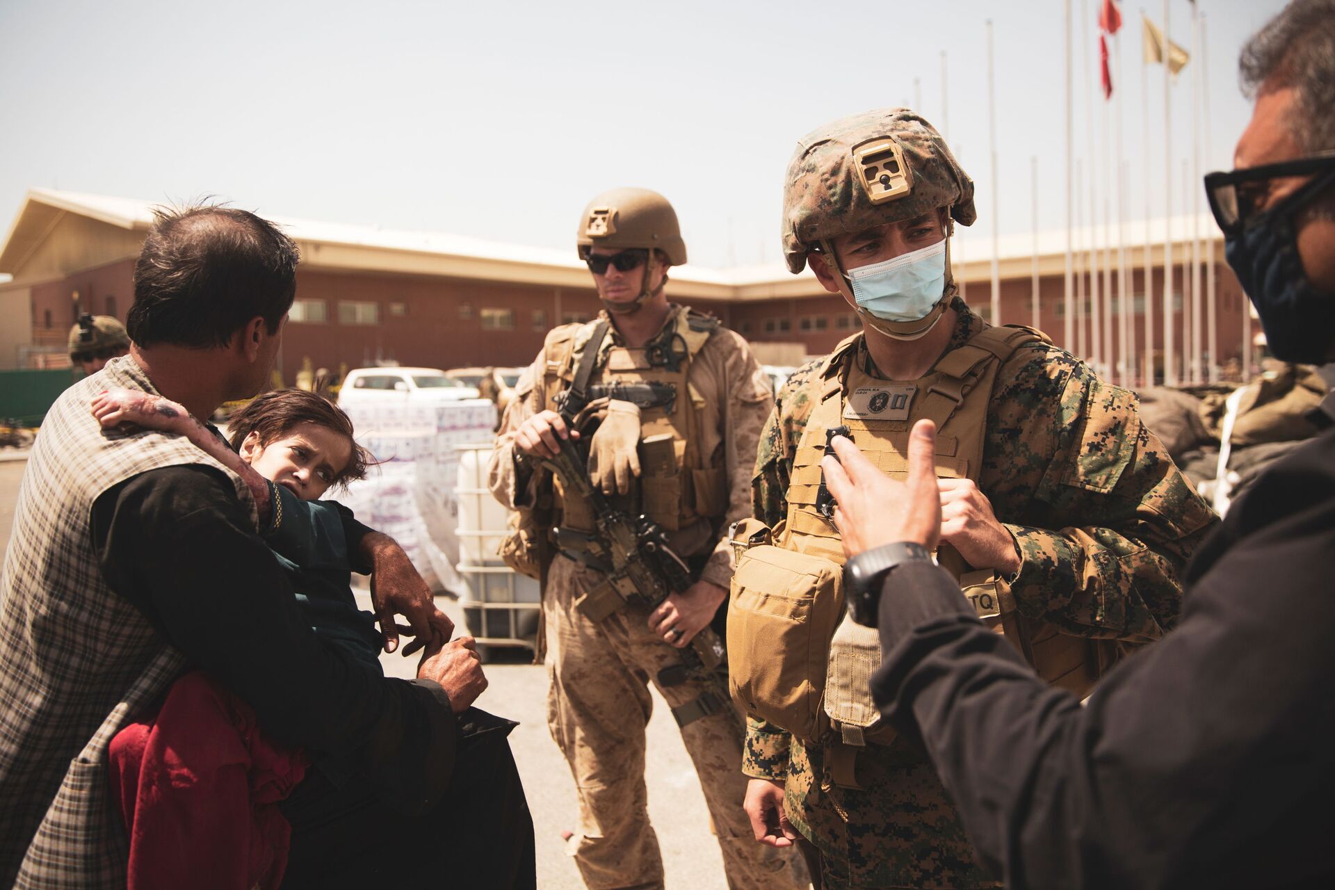 A U.S. Navy medical surgeon with the 24th Marine Expeditionary Unit (MEU) talks to an interpreter as he provides medical assistance to a family during an evacuation at Hamid Karzai International Airport, Kabul, Afghanistan, August 21, 2021. Picture taken August 21, 2021 - Sputnik International, 1920, 07.09.2021