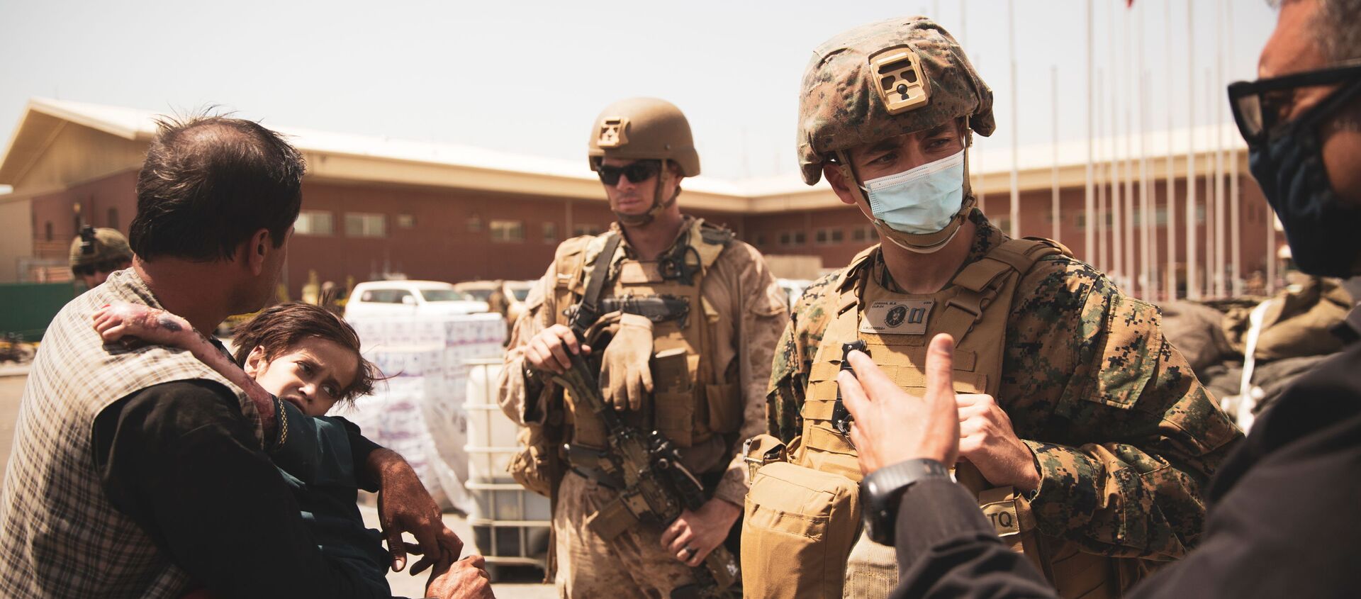 A U.S. Navy medical surgeon with the 24th Marine Expeditionary Unit (MEU) talks to an interpreter as he provides medical assistance to a family during an evacuation at Hamid Karzai International Airport, Kabul, Afghanistan, August 21, 2021. Picture taken August 21, 2021 - Sputnik International, 1920, 24.08.2021