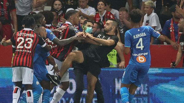 Marseille's French midfielder Dimitri Payet (2nd L) reacts as players from OGC Nice (red and black jersey) and Olympique de Marseille (blue jersey) stop a fan invading the pitch trying to kick Payet during the French L1 football match between OGC Nice and Olympique de Marseille (OM) at the Allianz Riviera stadium in Nice, southern France on August 22, 2021 - Sputnik International