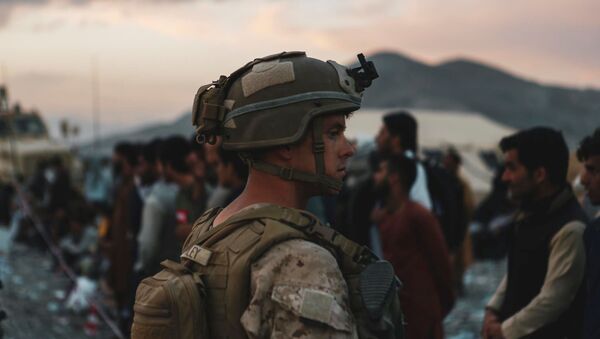A Marine assigned to Special Purpose Marine Air Ground Task Force-Crisis Response-Central Command assists evacuees during an evacuation at Hamid Karzai International Airport, in Kabul, Afghanistan - Sputnik International