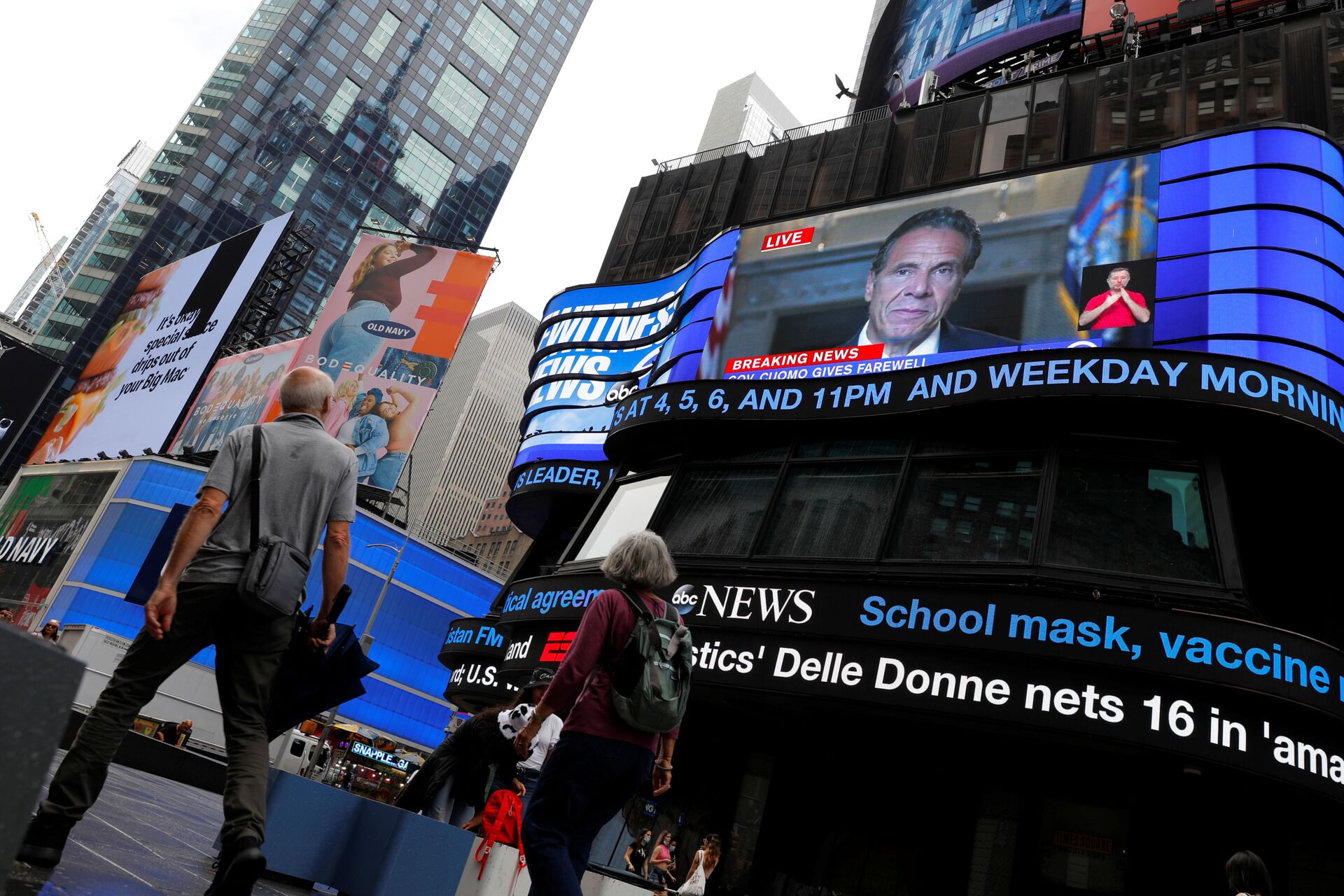 People walk by as a farewell speech by New York Governor Andrew Cuomo is broadcast live on a screen in Times Square on his final day in office in Manhattan, New York City, US, August 23, 2021 - Sputnik International, 1920, 16.11.2021