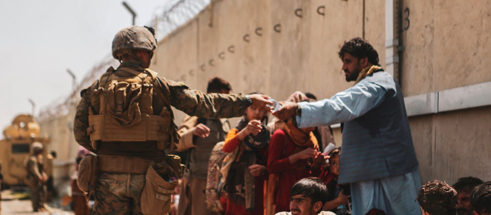 A US Marine passes out water to evacuees during an evacuation at Hamid Karzai International Airport, Kabul, Afghanistan, August 22, 2021 - Sputnik International, 1920, 25.08.2021