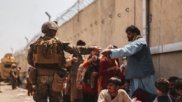 A US Marine passes out water to evacuees during an evacuation at Hamid Karzai International Airport, Kabul, Afghanistan, August 22, 2021 - Sputnik International