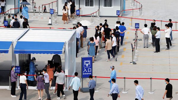 Staff members of Shanghai Pudong International Airport line up at a nucleic acid testing site to test for the coronavirus disease (COVID-19) in Shanghai, China August 20, 2021. Picture taken August 20, 2021. - Sputnik International
