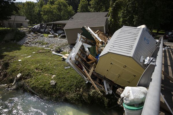 Structures and vehicles are piled up against a bridge over Trace Creek on 23 August 2021 in Waverly, Tennessee.  - Sputnik International
