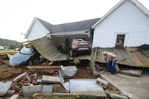 Ernest Hollis looks for items at his granddaughter's house that was devastated by floodwaters, Monday, 23 August 2021, in Waverly, Tenn. Heavy rains caused flooding in Middle Tennessee days ago and have resulted in multiple deaths and missing people as homes and rural roads were also washed away. - Sputnik International