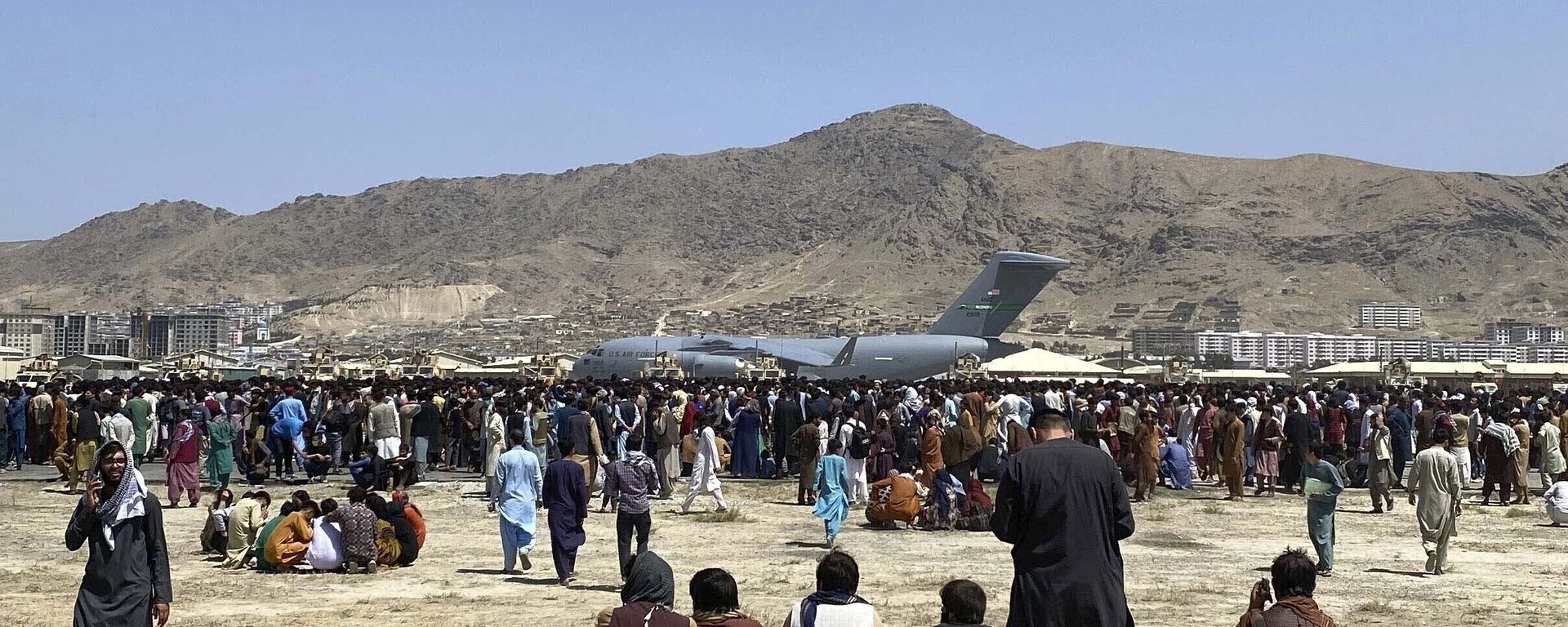 In this 16 August 2021 file photo, hundreds of people gather near a U.S. Air Force C-17 transport plane along the perimeter at the international airport in Kabul, Afghanistan after the Taliban takeover. - Sputnik International, 1920, 04.09.2021