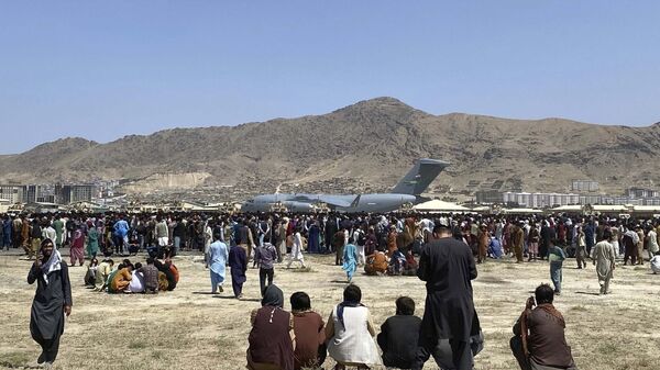  In this 16 August 2021 file photo, hundreds of people gather near a U.S. Air Force C-17 transport plane along the perimeter at the international airport in Kabul, Afghanistan after the Taliban takeover. - Sputnik International