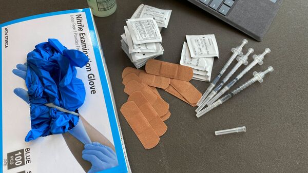 Syringes and gloves are pictured as students receive coronavirus disease (COVID-19) vaccines on the campus of the University of Memphis in Memphis, Tennessee, U.S., July 22, 2021. REUTERS/Karen Pulfer Focht/File Photo - Sputnik International