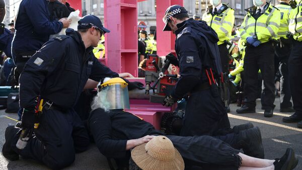 Police officers approach an activist during an Extinction Rebellion climate activists' protest, at Oxford Circus, in London, Britain, 25 August 2021. - Sputnik International
