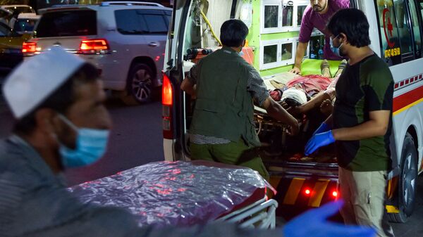 Medical staff bring an injured man to a hospital in an ambulance after two powerful explosions, which killed at least six people, outside the airport in Kabul on 26 August 2021. - Sputnik International