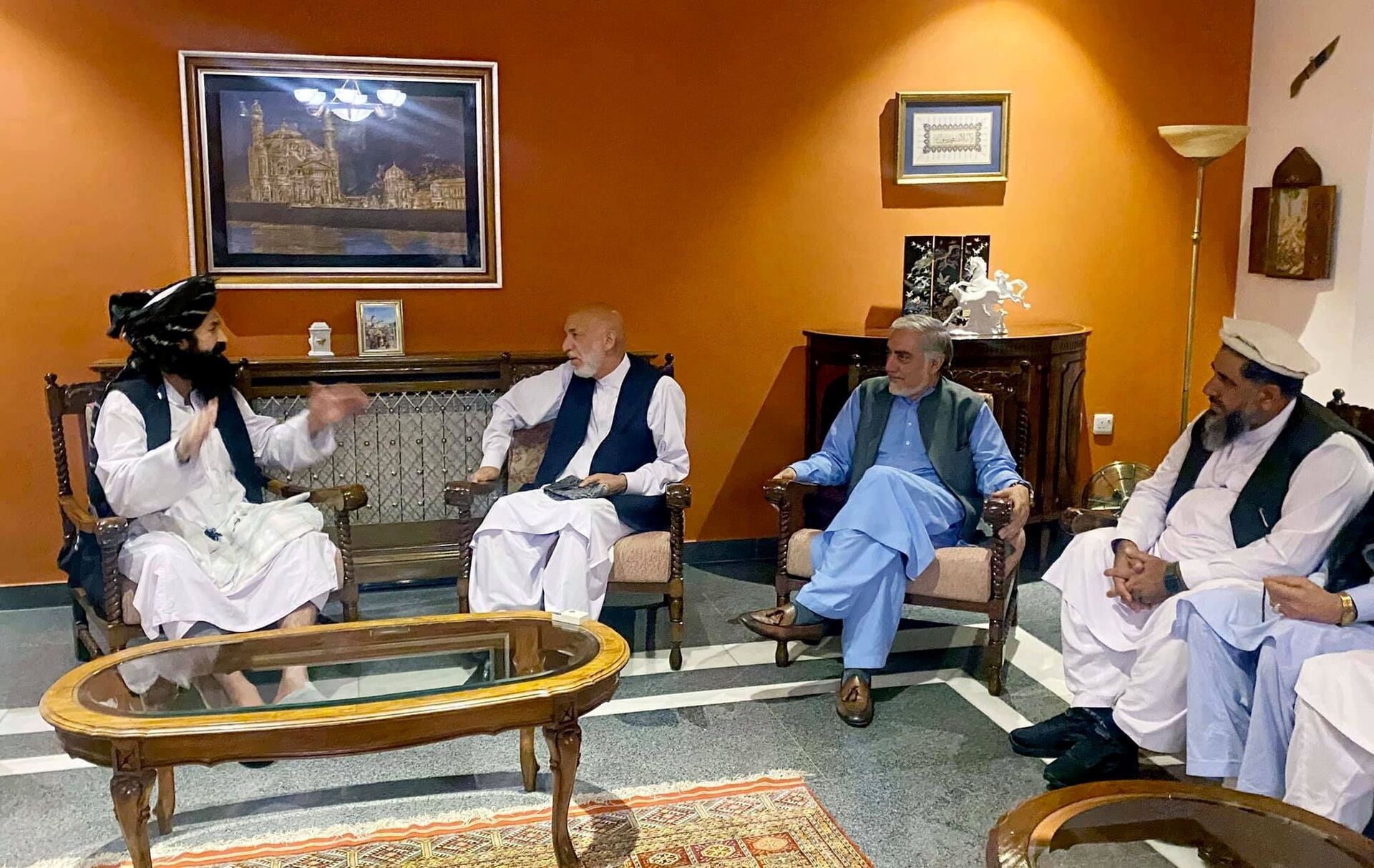 Former Afghan President Hamid Karzai, accompanied by the old government's main peace envoy, Abdullah Abdullah, sits for talks with members of the Taliban delegation in this undated handout uploaded August 19, 2021. - Sputnik International, 1920, 07.09.2021