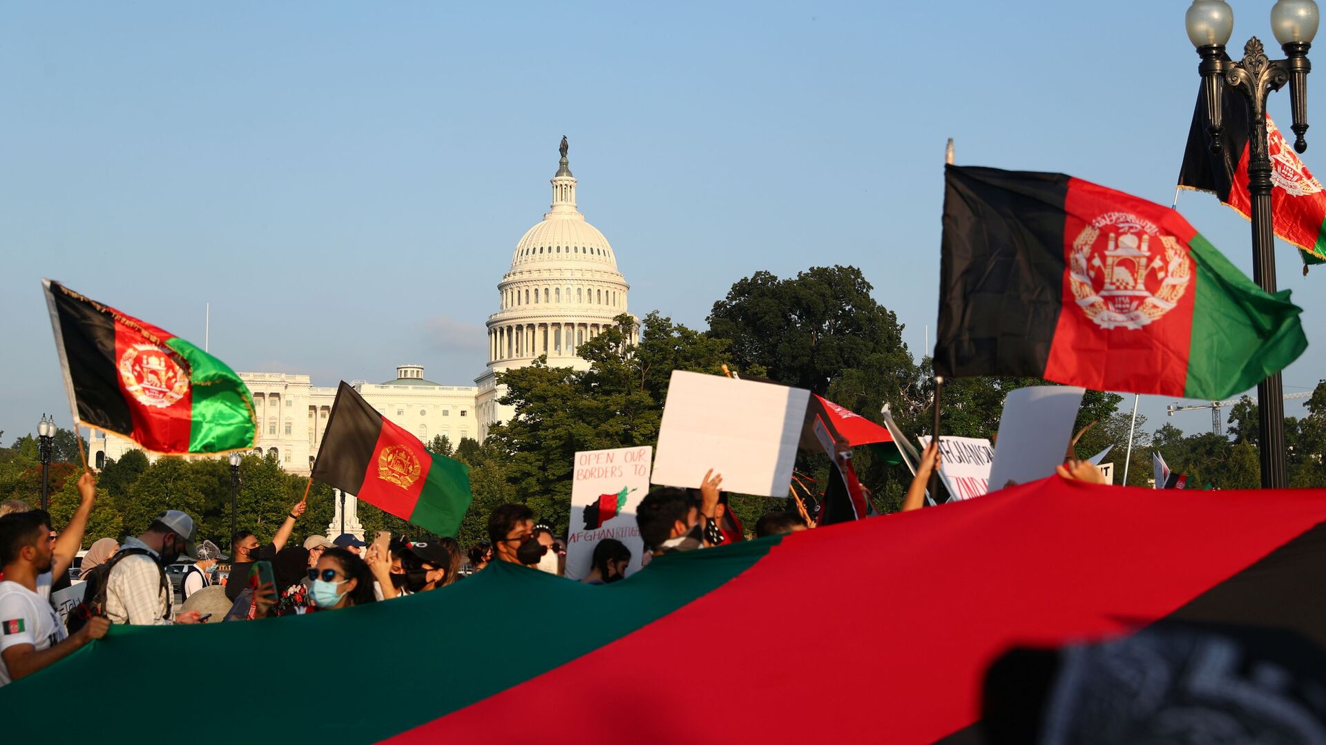 Protestors holding Afghanistan flags take part in a demonstration challenging the transparency of the evacuation process from Kabul Airport, near the U.S. Capitol, in Washington, U.S., August 28, 2021. REUTERS/Tom Brenner - Sputnik International, 1920, 07.09.2021