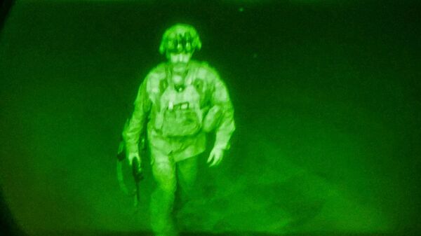 U.S. Army Major General Chris Donahue, commander of the 82nd Airborne Division, steps on board a C-17 transport plane as the last U.S. service member to leave Hamid Karzai International Airport in Kabul, Afghanistan August 30, 2021 in a photograph taken using night vision optics - Sputnik International